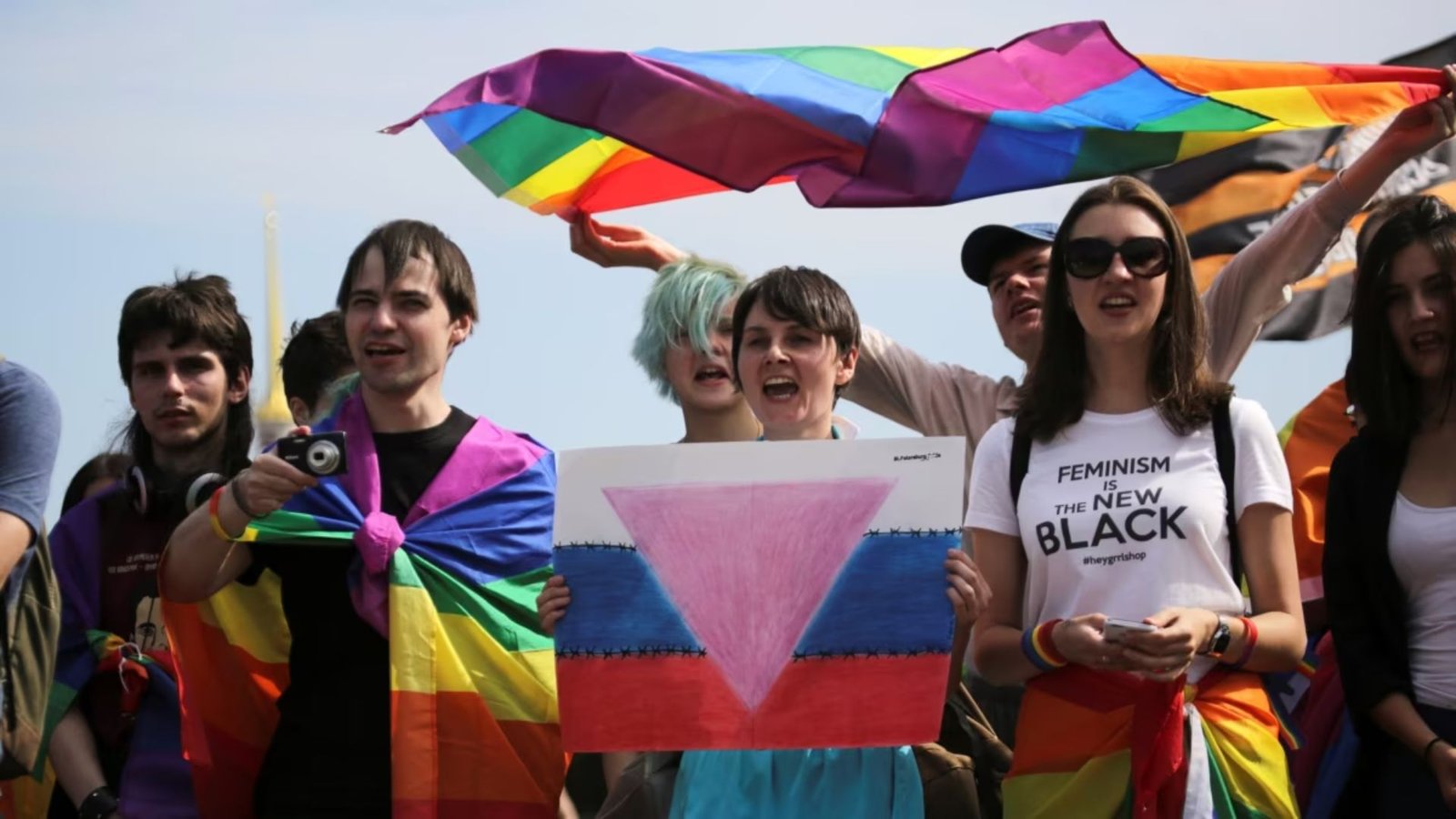 LGBTQ community protesting, holding their flag 