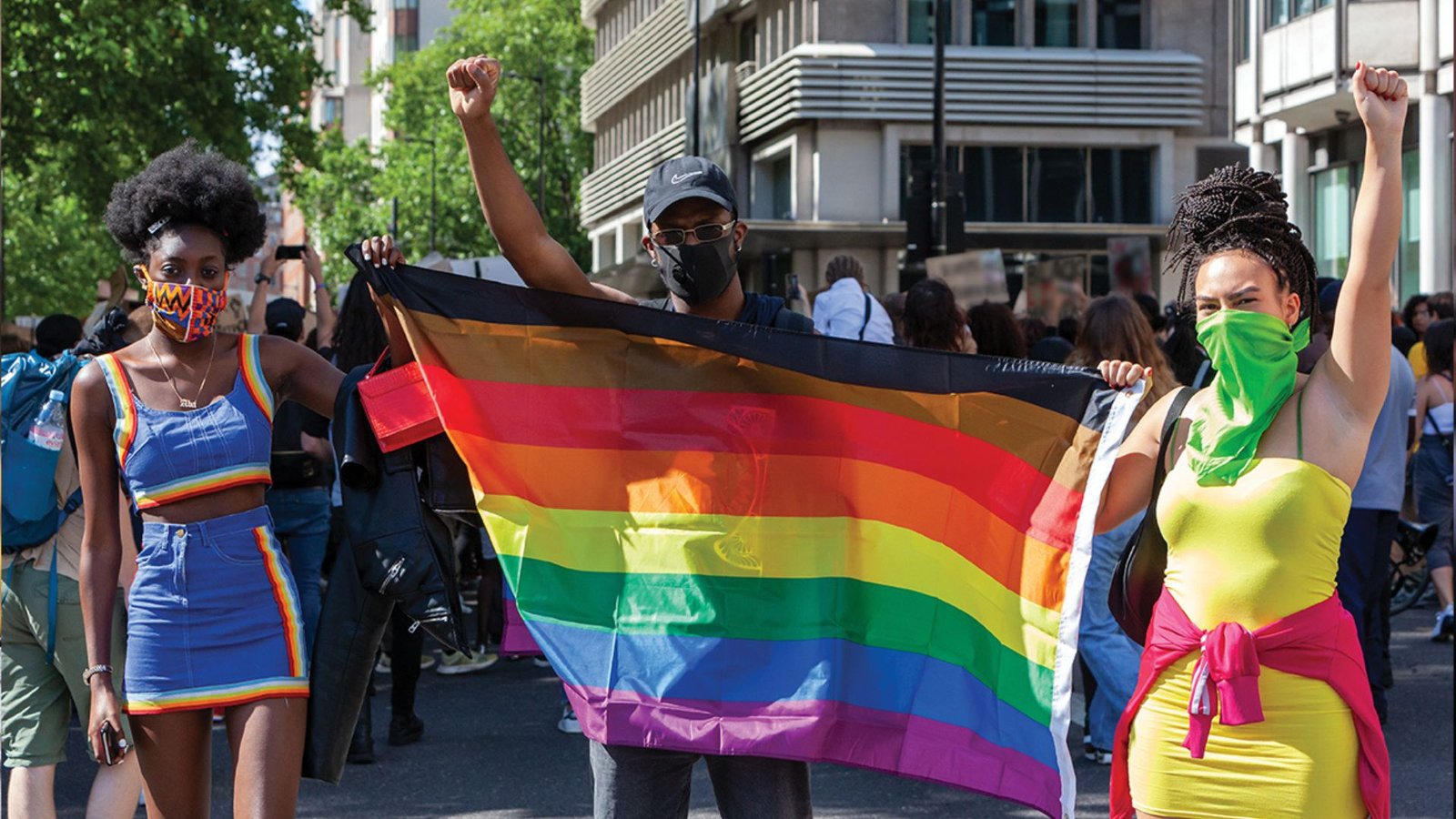 LGBTQ community protesting, holding their flag